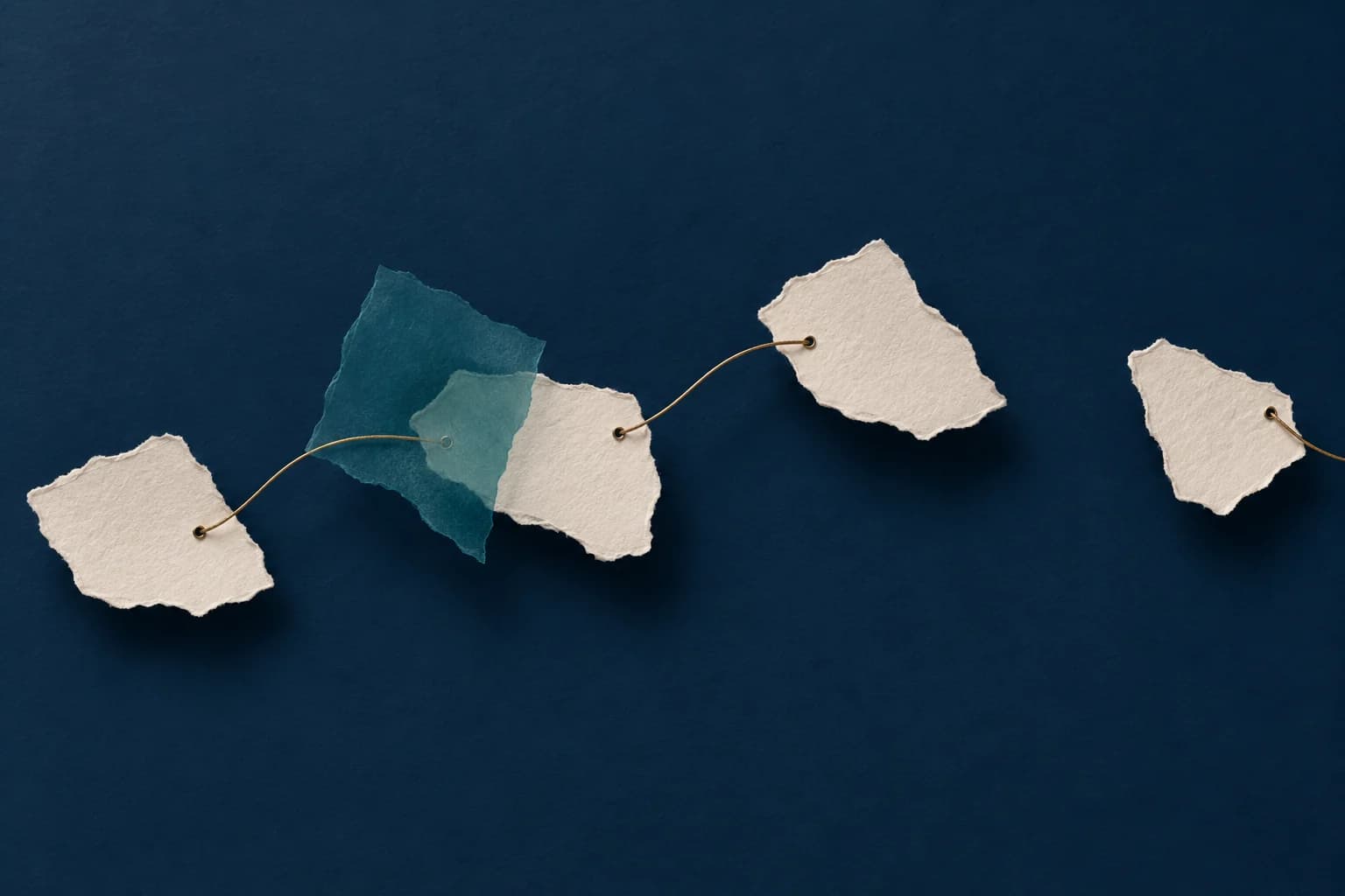 Conceptual illustration of torn paper fragments connected by a brass thread with a gap between them.